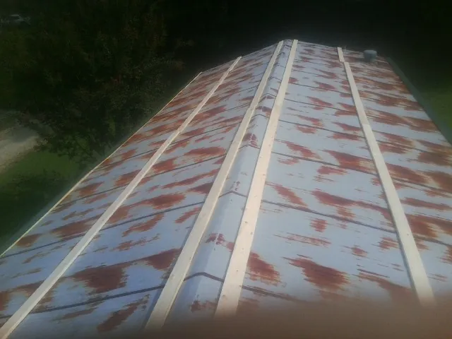 Rusted metal roof panels with new wood purlins before replacement — Storm Damage Roof Repair in Maybell by Roofing Brothers