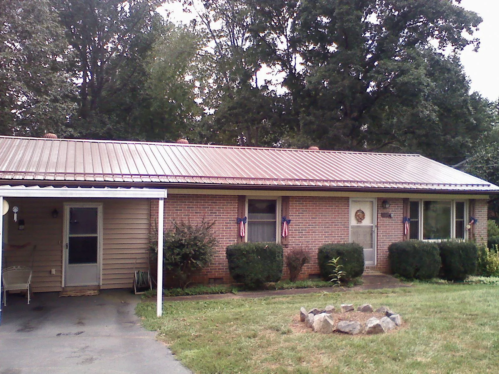 Bronze metal roof and carport on a brick ranch home — Roof Repair work by our crew in Maybell
